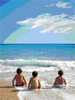 Three children sitting in the water at the beach