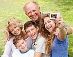 Family of 5 gathered outside taking a selfie