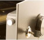 A safe with its door slightly ajar, revealing stacks of money and a key in the lock