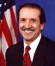 Attorney with a red tie and suit sitting in front of an american flag