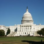 The **United States Capitol Building** under a clear blue sky.