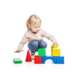 Baby girl building from toy blocks. isolated on white background.