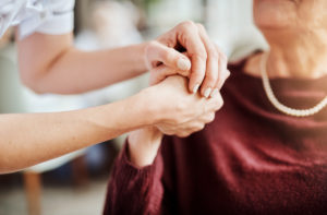 Woman holding hand of older woman