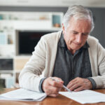 Older man signing estate planning documents