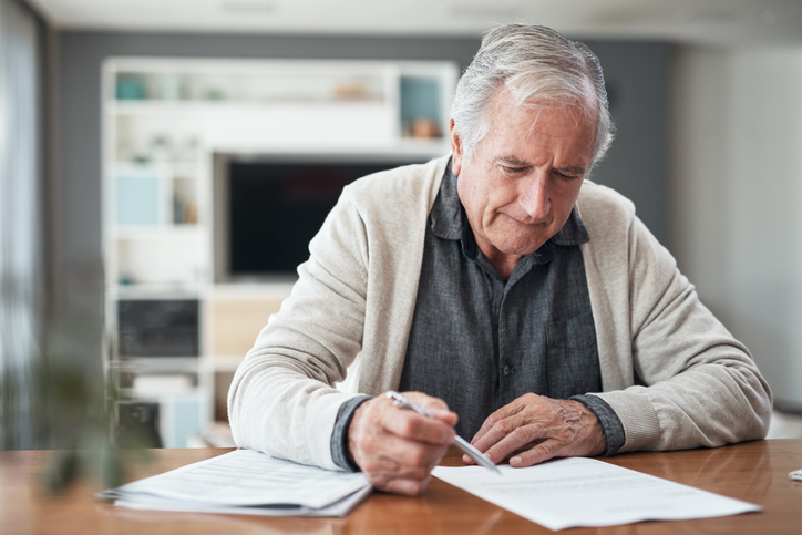 Older man signing estate planning documents