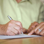 Senior woman signing estate planning documents