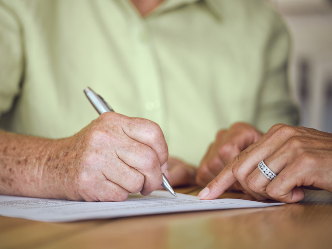 Senior woman signing estate planning documents